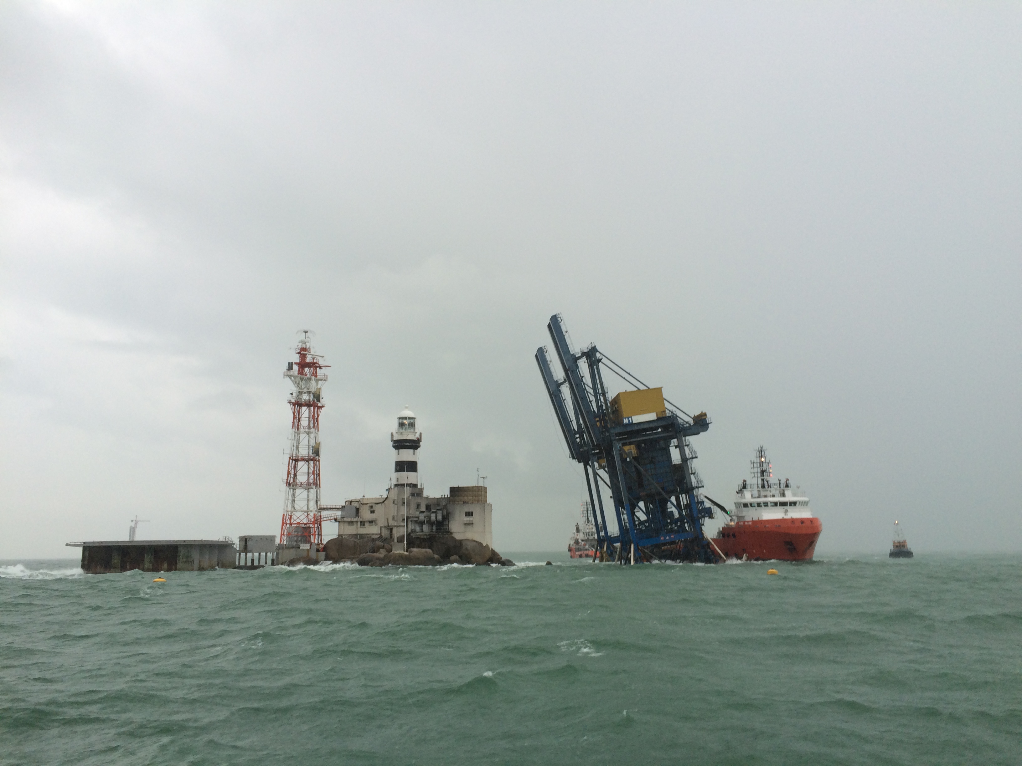 Temporary docks set up between a light house and a large vessel
